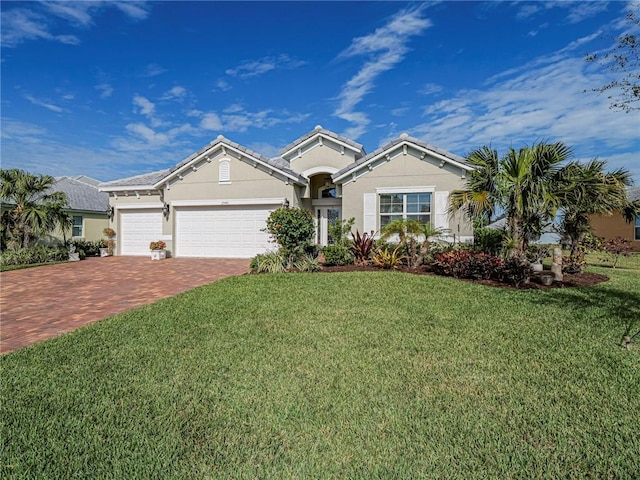 ranch-style house with an attached garage, decorative driveway, stucco siding, and a front lawn
