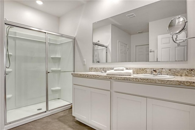 bathroom featuring a shower with door, tile patterned floors, and vanity