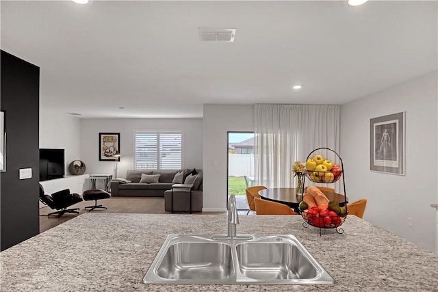 kitchen featuring sink and light stone countertops