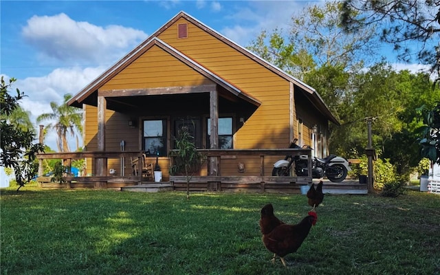 back of property featuring a deck and a lawn