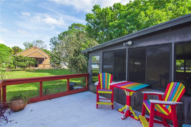 wooden terrace featuring a yard and a sunroom