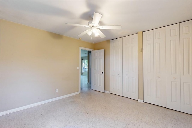 unfurnished bedroom with ceiling fan and multiple closets