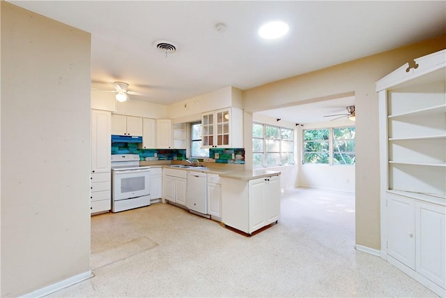 kitchen with white appliances, backsplash, white cabinets, sink, and kitchen peninsula