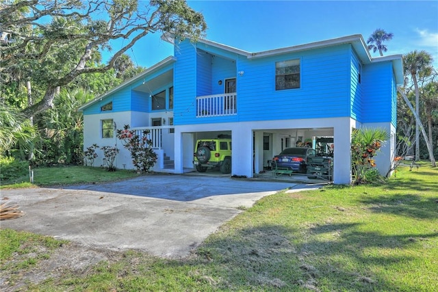 exterior space featuring a carport, a balcony, and a front yard