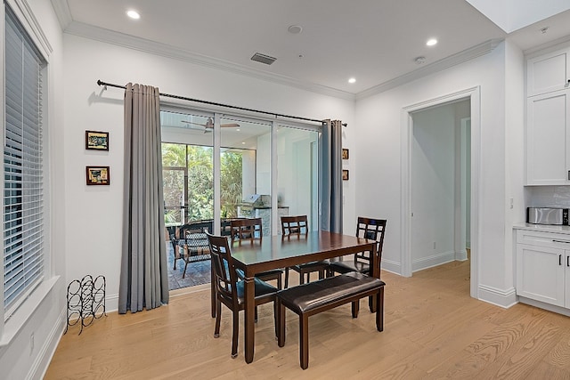 dining space with light wood-type flooring and crown molding