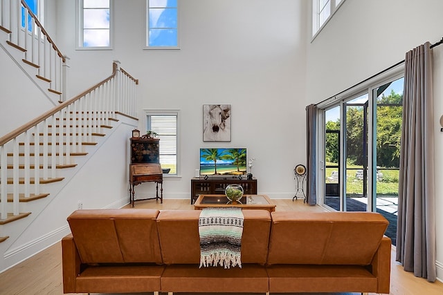 living room featuring light hardwood / wood-style floors and a high ceiling