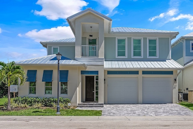 view of front of house with central AC unit and a garage