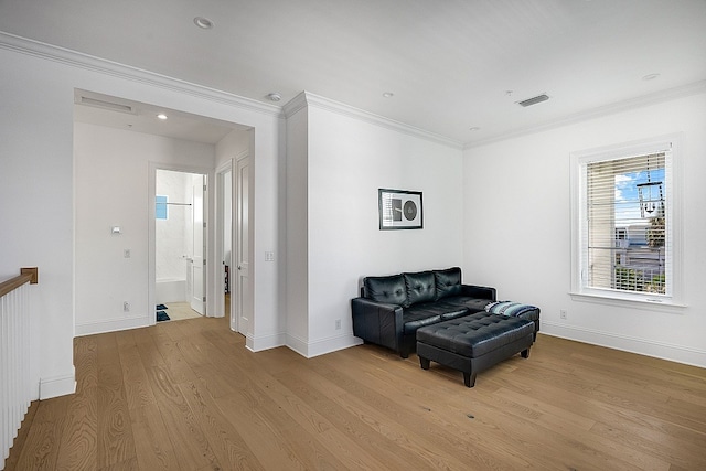 living area featuring light wood-type flooring and crown molding