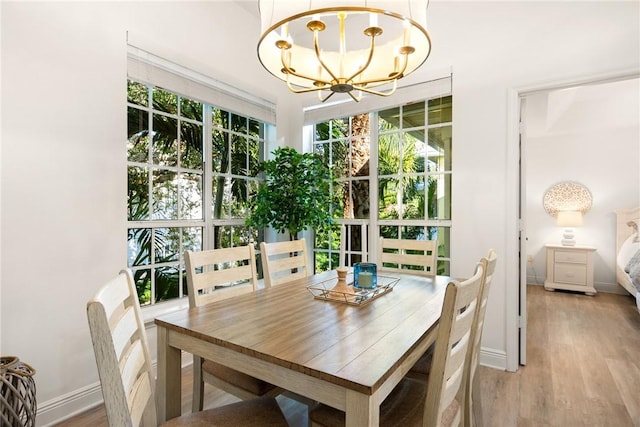 dining space featuring light hardwood / wood-style floors and a chandelier