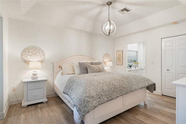 bedroom featuring light hardwood / wood-style floors and an inviting chandelier