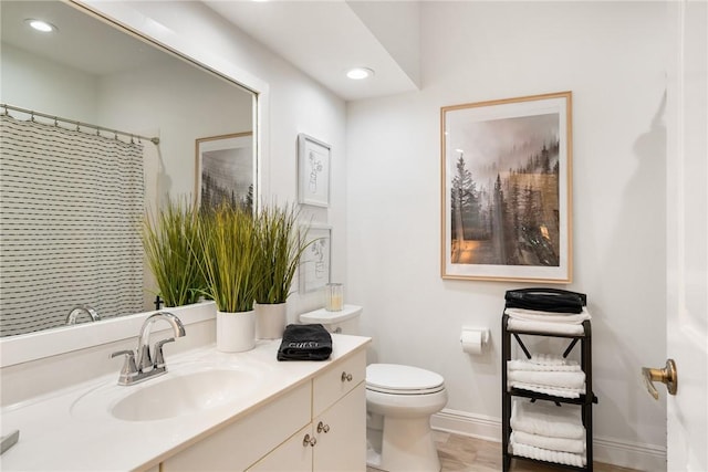 bathroom featuring a shower with curtain, vanity, and toilet