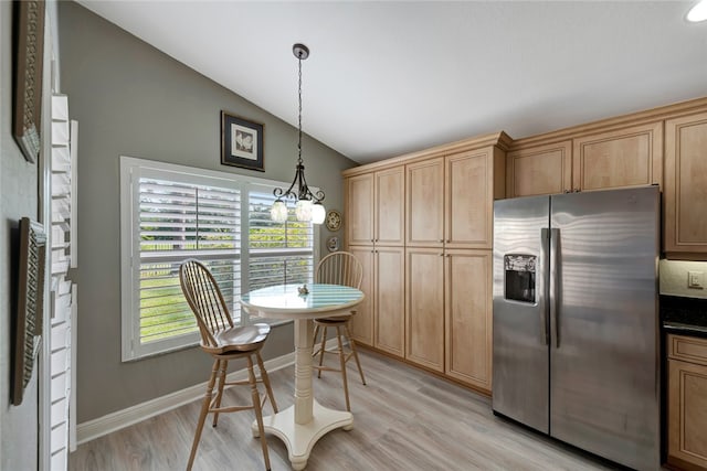 kitchen with stainless steel refrigerator with ice dispenser, a notable chandelier, light wood-type flooring, and vaulted ceiling