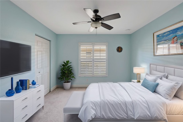 carpeted bedroom featuring a closet, multiple windows, and ceiling fan