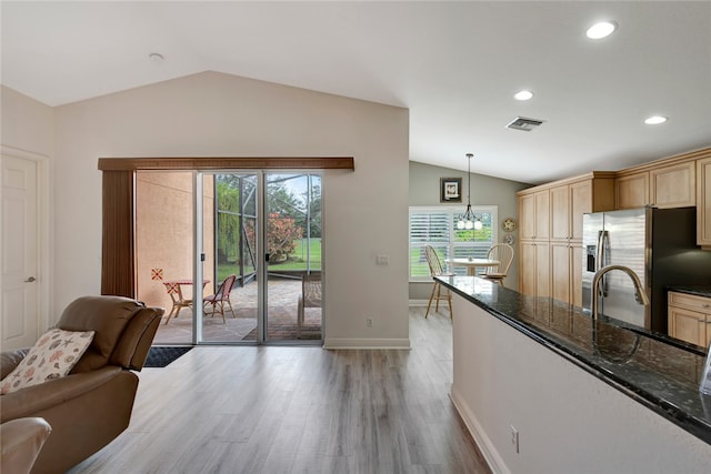 kitchen featuring light hardwood / wood-style flooring, pendant lighting, stainless steel fridge, and plenty of natural light