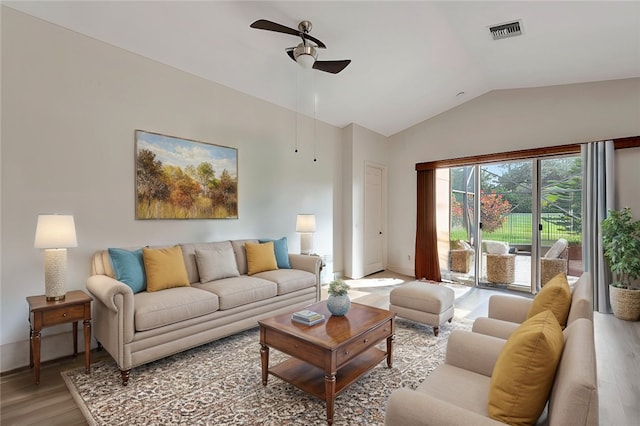 living room with hardwood / wood-style floors, ceiling fan, and vaulted ceiling