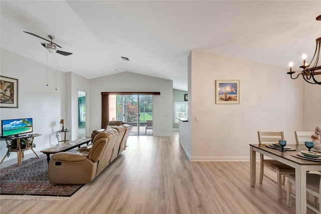 living room with ceiling fan with notable chandelier, light hardwood / wood-style floors, and lofted ceiling