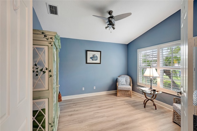 living area with light hardwood / wood-style flooring, ceiling fan, and vaulted ceiling