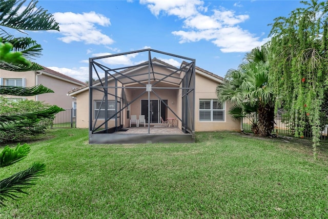 rear view of house with a patio area, a yard, and a lanai