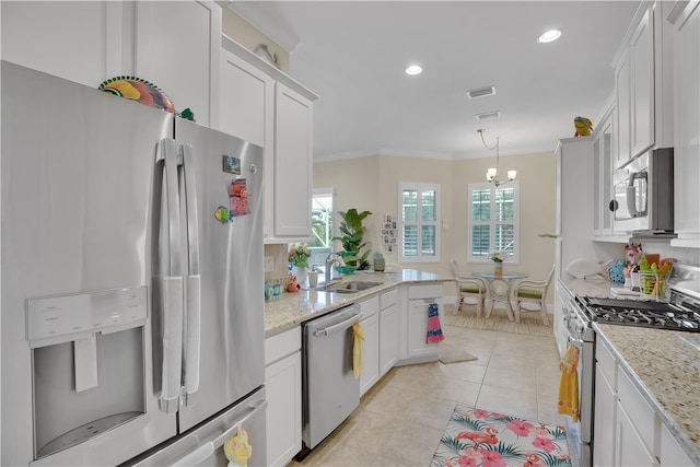 kitchen featuring white cabinetry, stainless steel appliances, ornamental molding, and light stone countertops