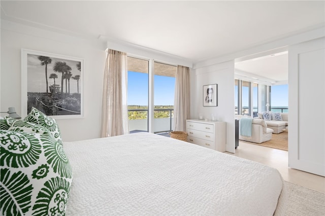 bedroom with expansive windows and a water view