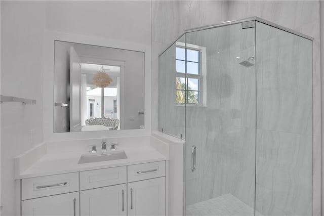 bathroom with a shower with shower door and vanity