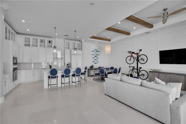 living room featuring ceiling fan and beamed ceiling