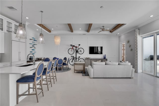 living room with a tray ceiling, sink, ceiling fan, and beam ceiling