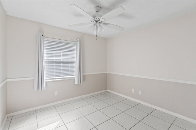 tiled spare room featuring ceiling fan