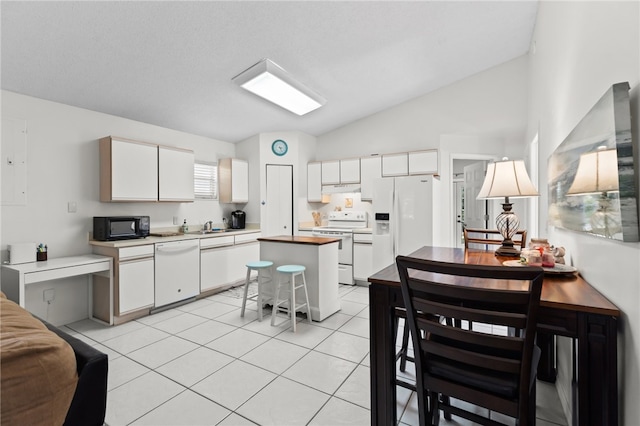 kitchen with white cabinetry, a center island, sink, lofted ceiling, and white appliances