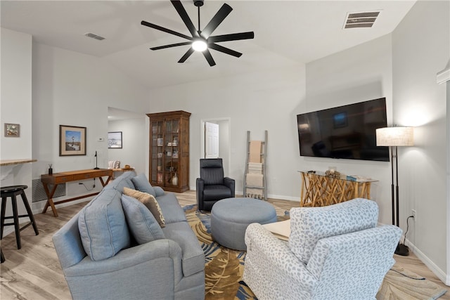 living room featuring light hardwood / wood-style flooring, lofted ceiling, and ceiling fan