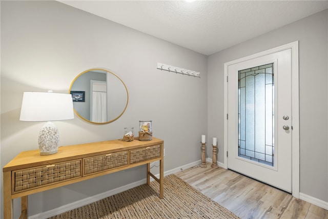 entryway featuring a textured ceiling and light hardwood / wood-style floors