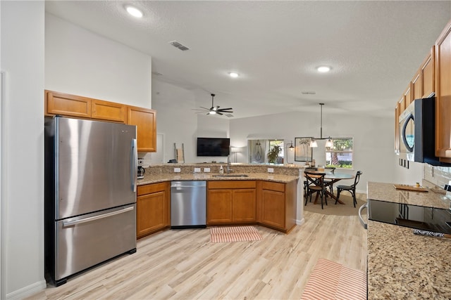 kitchen with stainless steel appliances, lofted ceiling, light hardwood / wood-style floors, kitchen peninsula, and pendant lighting