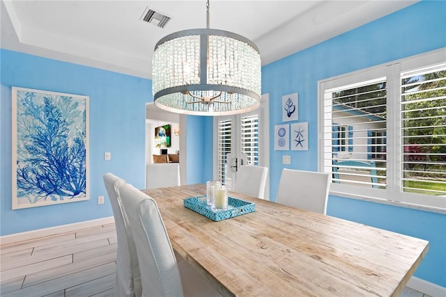 unfurnished dining area featuring plenty of natural light, a chandelier, and light hardwood / wood-style flooring