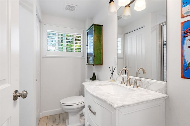 bathroom with vanity, toilet, and hardwood / wood-style floors