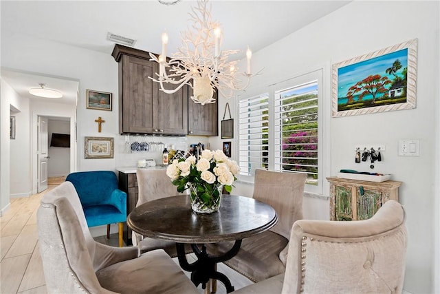 dining room with light hardwood / wood-style floors and a chandelier