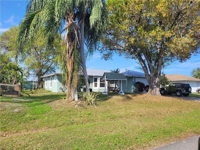 single story home featuring a front lawn and fence