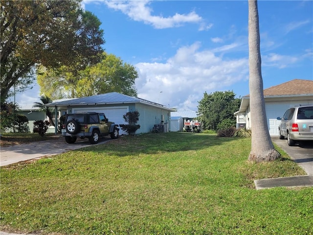 view of property exterior with driveway, a yard, and an attached garage