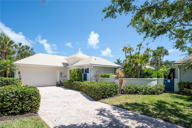 single story home with a garage and a front lawn