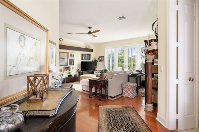 living room featuring wood-type flooring and ceiling fan