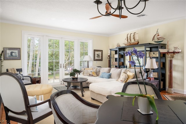 living room with a wealth of natural light, french doors, crown molding, and wood-type flooring