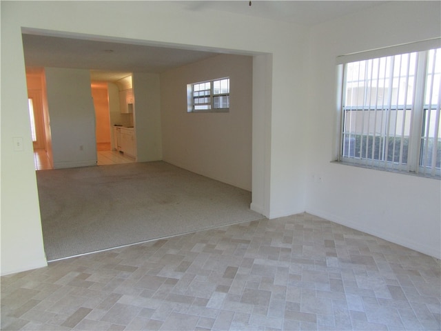 carpeted empty room featuring a wealth of natural light