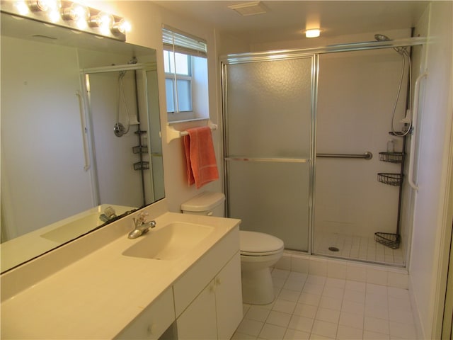 bathroom featuring walk in shower, vanity, toilet, and tile patterned floors