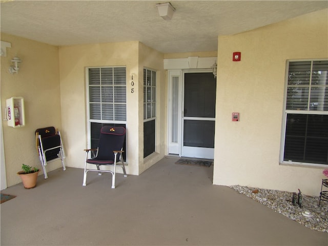 view of exterior entry with a patio