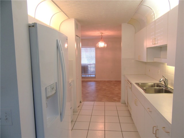 kitchen with sink, light tile patterned floors, decorative light fixtures, white appliances, and white cabinets