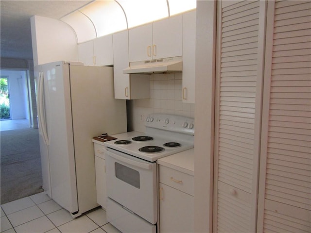 720 Lake Orchid Cir Unit 108, Vero Beach, FL 32962 - kitchen with under cabinet range hood, white appliances, light countertops, white cabinets, and light tile patterned flooring