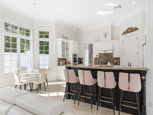 7 Beachside Dr, Vero Beach, FL 32963 - kitchen featuring visible vents, ornamental molding, and stainless steel oven