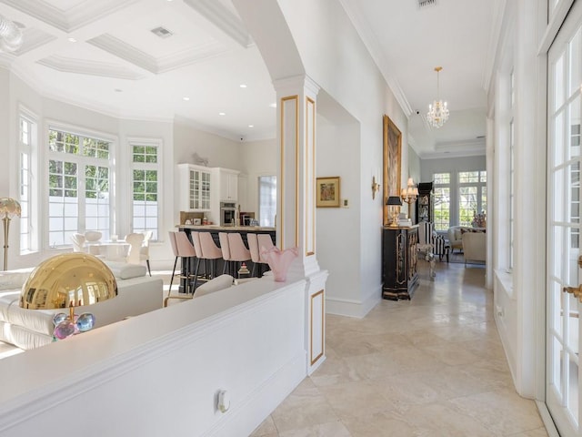 7 Beachside Dr, Vero Beach, FL 32963 - hallway featuring baseboards, an inviting chandelier, ornamental molding, visible vents, and ornate columns