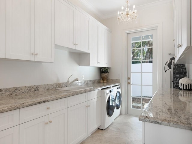 7 Beachside Dr, Vero Beach, FL 32963 - washroom featuring an inviting chandelier, a sink, ornamental molding, cabinet space, and washer and clothes dryer