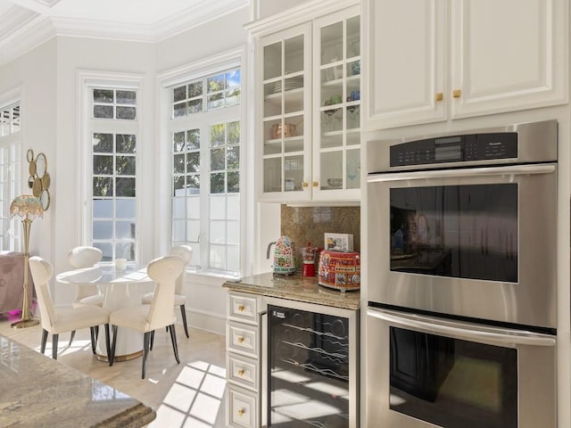 7 Beachside Dr, Vero Beach, FL 32963 - bar featuring crown molding, double oven, tasteful backsplash, beverage cooler, and baseboards