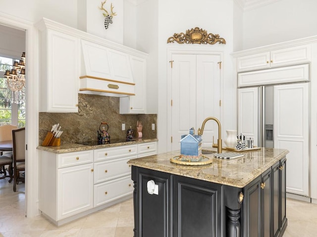 7 Beachside Dr, Vero Beach, FL 32963 - kitchen with black electric cooktop, paneled built in refrigerator, white cabinetry, light stone countertops, and backsplash